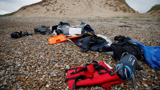 A damaged inflatable dinghy, outboard motors, life jackets and sleeping bags abandoned by migrants are seen on the beach near the Slack dunes, the day after 27 migrants died when their dinghy deflated as they attempted to cross the English Channel, on November 25, 2021, (REUTERS/Pascal Rossignol)(REUTERS)
