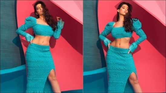 Nora Fatehi flaunts washboard abs in blue body-hugging co-ord set | Check pics Nora teamed it with a matching body-hugging blue skirt that came with a knee-high side slit to add to the oomph factor.(Instagram/norafatehi)