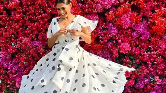 Taking to her social media handle, Kubbra shared a slew of pictures featuring her in the white base flared midi dress that came with black polka dots and sported a plunging neckline along with a cinched waist to add to the oomph factor.(Instagram/gauriandnainika)