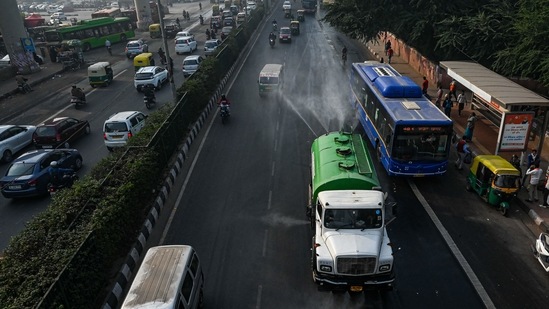 A municipal truck sprays water along a street amid smoggy conditions in New Delhi.(AFP)