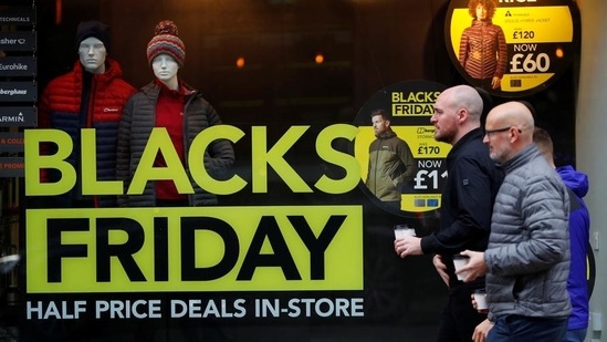 People walk past a sign advertising Black Friday offers in Manchester, the United Kingdom.&nbsp;(File Photo / REUTERS)