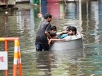 Young men sit in a tub as another man pushes them on a waterlogged street following heavy rain in Chennai, Saturday. (PTI) Young men sit in a tub as another man pushes them on a waterlogged street following heavy rain in Chennai, Saturday. (PTI)