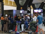 Travelers queue at a check-in counter at OR Tambo International Airport in Johannesburg on November 27, 2021, after several countries banned flights from South Africa following the discovery of a new Covid-19 variant Omicron. (Photo by Phill Magakoe / AFP) Travelers queue at a check-in counter at OR Tambo International Airport in Johannesburg on November 27, 2021, after several countries banned flights from South Africa following the discovery of a new Covid-19 variant Omicron. (Photo by Phill Magakoe / AFP)