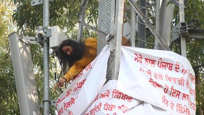 Swarn Singh — an ETT qualified teacher posted at a primary school in Barnala — atop a mobile tower at the Punjab MLA Hostel in Chandigarh. (HT Photo)