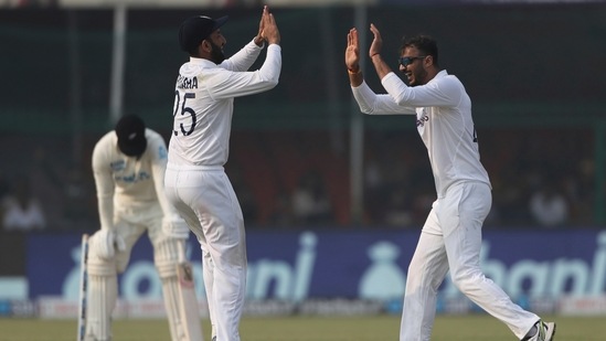 India's bowler Axar Patel, right, celebrates the dismissal of New Zealand's Tom Blundell with his teammate Cheteshwar Pujara during the day three of their first test cricket match in Kanpur, India, Saturday, Nov. 27, 2021.&nbsp;(AP)