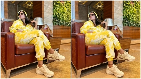 Making a case for tie-dye fashion, Hina chose an athleisure fit for her travel look. Her outfit includes a hoodie jacket featuring soothing yellow and white print, front zipper, double-sided pockets, and gathered cuffs and hem.(Instagram/@realhinakhan)