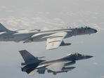 A Taiwanese F-16 fighter jet flying next to a Chinese H-6 bomber (top) off the coast of Taiwan. A Taiwanese F-16 fighter jet flying next to a Chinese H-6 bomber (top) off the coast of Taiwan.