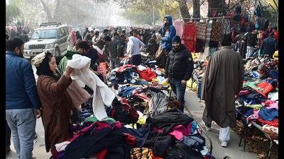 People buy warm clothes at a market in Srinagar on Sunday as Kashmir continues to reel under cold conditions. (ANI)