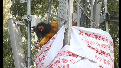 The protesting teacher on top of the water tower in Chandigarh. (HT photo)