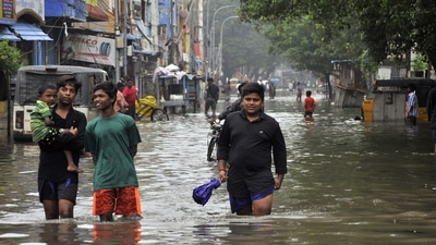 People wade through a knee-deep waterlogged road following heavy rainfall in Chennai. (ANI File Photo) People wade through a knee-deep waterlogged road following heavy rainfall in Chennai. (ANI File Photo)