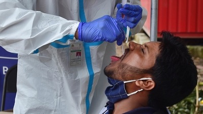 A medic collects sample from a passenger for Covid test at the KSRTC bus stand in Bengaluru (PTI Photo) A medic collects sample from a passenger for Covid test at the KSRTC bus stand in Bengaluru (PTI Photo)