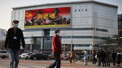 An advertisement of the People's Liberation Army overlooks a street scene. (REUTERS)