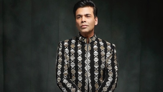 The pictures featured the director donning a bandhgala sherwani that came in a black base and sported intricate embroidery in bright white and beige threads to add a pop of colour.(Instagram/karanjohar)