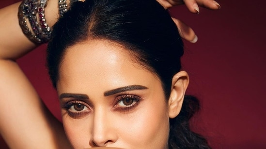 Pulling back her luscious tresses into a mid-parted low ponytail hairstyle, Nushrratt accessorised her look with a set of multi-coloured bangles and a neck piece from Amrapali Jewels.(Instagram/nushrrattbharuccha)