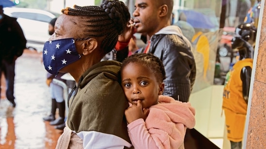 A woman carries a child in Pretoria, South Africa. Scientists in South Africa, where omicron was first identified, are scrambling to combat its spread.(AP) A woman carries a child in Pretoria, South Africa. Scientists in South Africa, where omicron was first identified, are scrambling to combat its spread.(AP)