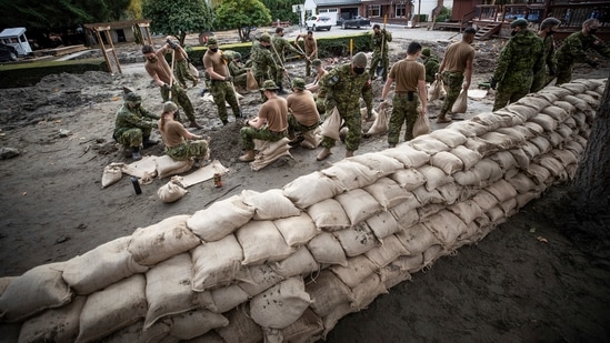 Prime Minister Justin Trudeau visited affected areas on Friday, after deploying the military to help with sandbagging. In picture - Canadian Forces fill sandbags to build a temporary dike behind houses on Clayburn Creek ahead of a rainfall warning in Abbotsford, British Columbia.(AP) Prime Minister Justin Trudeau visited affected areas on Friday, after deploying the military to help with sandbagging. In picture - Canadian Forces fill sandbags to build a temporary dike behind houses on Clayburn Creek ahead of a rainfall warning in Abbotsford, British Columbia.(AP)