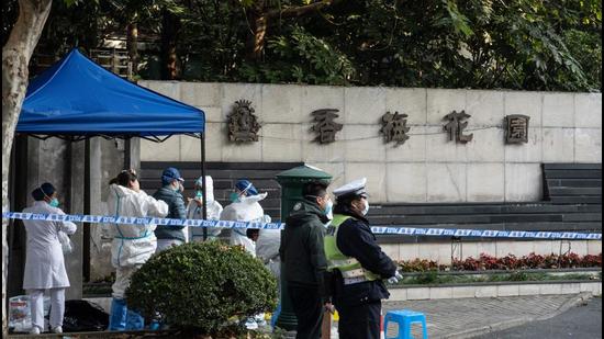 Police officers and medical staff members wearing personal protective equipment (PPE) are seen outside a residental area that is under restrictions following a recent coronavirus outbreak in Shanghai. (AFP) Police officers and medical staff members wearing personal protective equipment (PPE) are seen outside a residental area that is under restrictions following a recent coronavirus outbreak in Shanghai. (AFP)