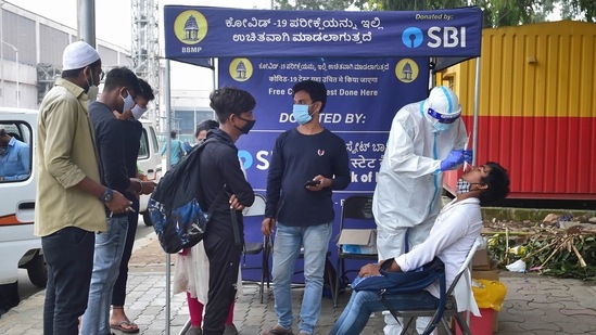 A medic keeps sample for the Covid-19 test of passengers at KSRTC bus stand in Bengaluru.(PTI)