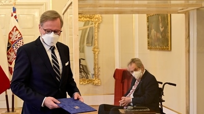 Czech President Milos Zeman, right, in a transparent cube because he tested positive to Covid-19, appoints ODS leader Petr Fiala, left, as Czech Prime Minister at the Lany manor, near Prague. (via AP)