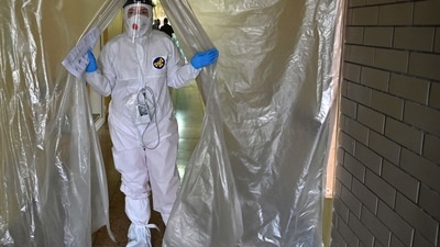 A medical staff wearing personal protective equipment leaves the intensive care unit in one of the hospitals. (AFP) A medical staff wearing personal protective equipment leaves the intensive care unit in one of the hospitals. (AFP)
