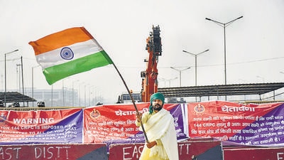 A farmer waves the Indian tri-colour at Ghazipur protest site after a bill to repeal the farm laws was passed in Parliament on Monday. (Sakib Ali/HT photo) A farmer waves the Indian tri-colour at Ghazipur protest site after a bill to repeal the farm laws was passed in Parliament on Monday. (Sakib Ali/HT photo)