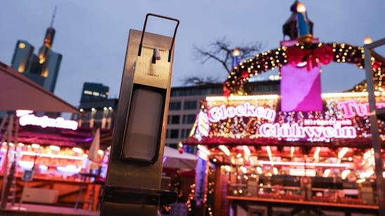 A dispenser of hand sanitizer is pictured at the entrance of a stand selling mulled wine (Gluehwein) in Frankfurt am Main, western Germany.(Photo by Yann Schreiber / AFP)