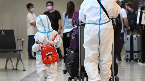 International travellers wearing personal protective equipment (PPE) arrive at Melbourne's Tullamarine Airport, on November 29.(AFP Photo)