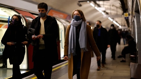 Passengers, many wearing face coverings to combat the spread of Covid-19, walk along a platform as they travel on the London underground in central London.(AFP Photo)