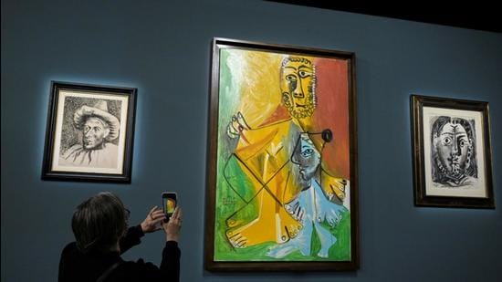 An attendee photographs a painting prior to the auction of 11 Picasso paintings and works at the Bellagio Hotel in Las Vegas, Nevada, US on October 23, 2021. Picasso’s Woman in a Hat was sold for 23.575 million yuan ($3.69mn) at a Beijing auction on Sunday. (REUTERS)