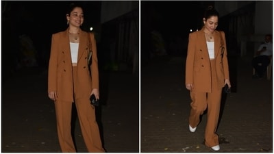 Tamannaah accessorised her monochrome powersuit with a pair of white lace-up chunky sneakers, a black face mask, and a Celine mini bag in camouflage print and embroidered logo. For jewellery, the star chose a layered gold chain with a pendant and triple hoop earrings. (HT Photo/Varinder Chawla) Tamannaah accessorised her monochrome powersuit with a pair of white lace-up chunky sneakers, a black face mask, and a Celine mini bag in camouflage print and embroidered logo. For jewellery, the star chose a layered gold chain with a pendant and triple hoop earrings. (HT Photo/Varinder Chawla)