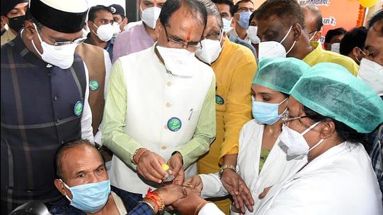 Madhya Pradesh chief minister Shivraj Singh Chouhan puts a mark on a hand of a beneficiary after receiving a dose of the Covid-19 vaccine during launch of mega inoculation drive, in Bhopal on August 25. (ANI)