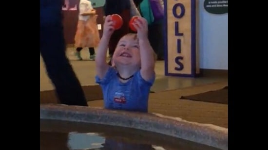 This baby boy is super happy to get two balls from a fountain.&nbsp;(reddit/@LlamaRoo5)