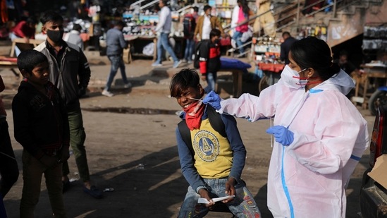 A boy reacts as a healthcare worker collects Covid-19 test swab sample in New Delhi on Tuesday.&nbsp;(Reuters Photo)