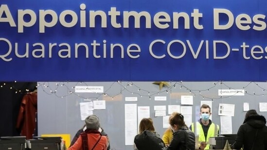 People wait in front of an "Appointment Desk" for quarantine and coronavirus disease (COVID-19) test appointments inside Schiphol Airport, after Dutch health authorities said that 61 people who arrived in Amsterdam on flights from South Africa tested positive for COVID-19, in Amsterdam, Netherlands, November 27, 2021. REUTERS/Eva Plevier