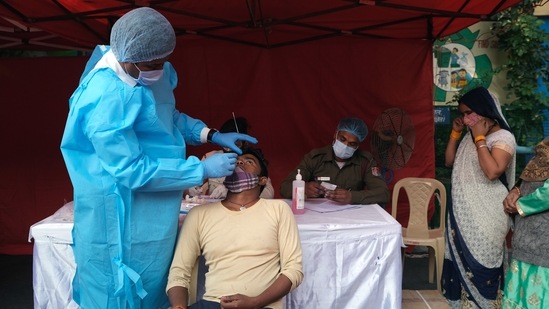 A person takes an RT-PCR test before receiving a dose of the Covid-19 vaccine at a vaccination center.(Bloomberg)