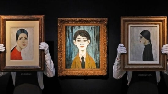 Christie's employees hold paintings by Laurence Stephen Lowry during an art pre-sale photo call at Christie's auction house in London, (AP Photo/Frank Augstein)(AP)