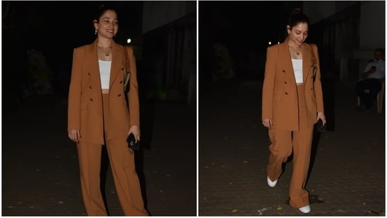 Tamannaah accessorised her monochrome powersuit with a pair of white lace-up chunky sneakers, a black face mask, and a Celine mini bag in camouflage print and embroidered logo. For jewellery, the star chose a layered gold chain with a pendant and triple hoop earrings.(HT Photo/Varinder Chawla)