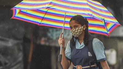 A young girl walks to school amid a downpour in Mumbai on Wednesday. (PTI)