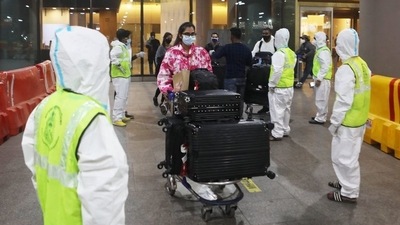Passengers wearing protective face masks leave after arriving at Mumbai International Airport. (Reuters Photo)