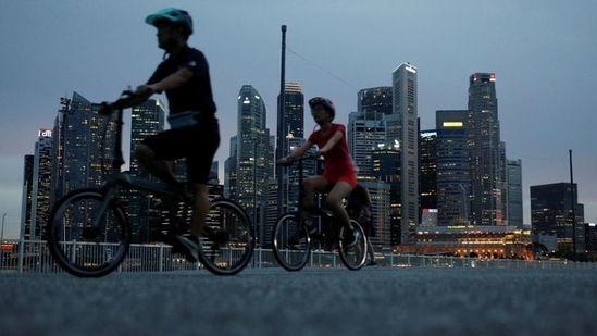 Cyclists pass the city skyline during the coronavirus disease (COVID-19) outbreak, in Singapore.(REUTERS)