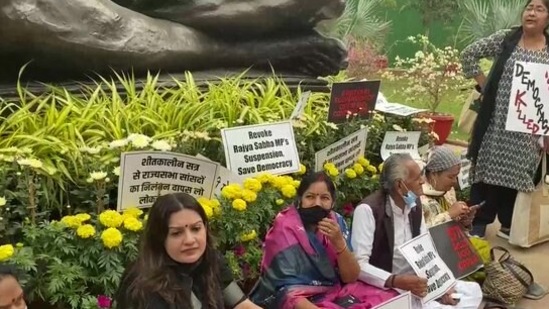 Suspended MPs protest near Gandhi statute on Parliament premises. (ANI Twitter)