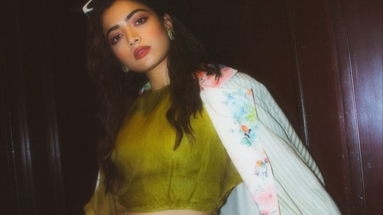 Often referred to as the national crush of India, Rashmika Mandanna knows how to keep fans hooked with her sartorial elegance and her latest pictures in a green crop top and floral coat are enough to back our claim.(Instagram/rashmika_mandanna)