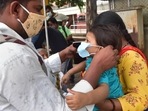 A man helps his son to wear mask at Covid-19 test centre at KSRTC bus stand in Bengaluru.(PTI) A man helps his son to wear mask at Covid-19 test centre at KSRTC bus stand in Bengaluru.(PTI)