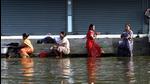 Women wash clothes on a waterlogged street in Chennai on Wednesday. (PTI) Women wash clothes on a waterlogged street in Chennai on Wednesday. (PTI)