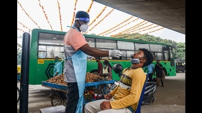 A nurse collects swab sample of a commuter for Covid-19 test in Bengaluru on Thursday. (PTI) A nurse collects swab sample of a commuter for Covid-19 test in Bengaluru on Thursday. (PTI)