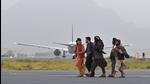 Taliban fighters walk past as an aircraft prepares to take off from the airport in Kabul in September. (AFP) Taliban fighters walk past as an aircraft prepares to take off from the airport in Kabul in September. (AFP)