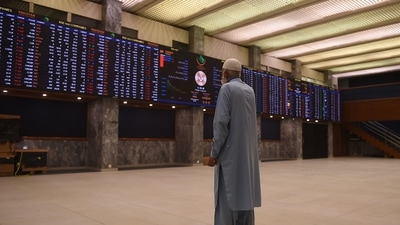 A stockbroker looks at share prices on an index board during a trading session at the Pakistan Stock Exchange (PSX) in Karachi on December 2, 2021. (Photo by Rizwan TABASSUM / AFP) A stockbroker looks at share prices on an index board during a trading session at the Pakistan Stock Exchange (PSX) in Karachi on December 2, 2021. (Photo by Rizwan TABASSUM / AFP)