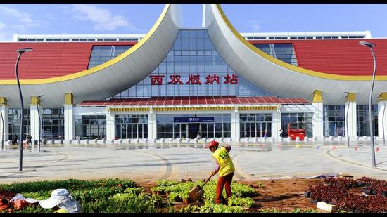Landscapers work outside of a railway station in Xishuangbanna in southwestern China's Yunnan Province on Tuesday. (AP)