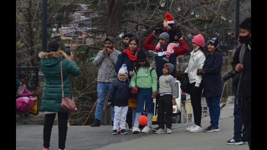 Tourists at the Ridge in Shimla, which recorded a low of 5.2 degrees Celsius, on Thursday evening. The state capital got mild rainfall on Friday morning. (Deepak Sansta/HT)