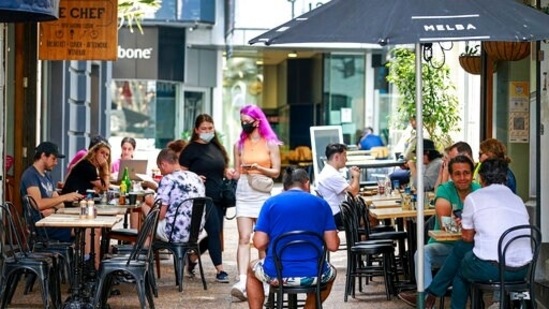 Customers eat outside in cafes in central Auckland, New Zealand, Friday, Dec. 3, 2021. (Alex Burton/NZ Herald via AP) Customers eat outside in cafes in central Auckland, New Zealand, Friday, Dec. 3, 2021. (Alex Burton/NZ Herald via AP)